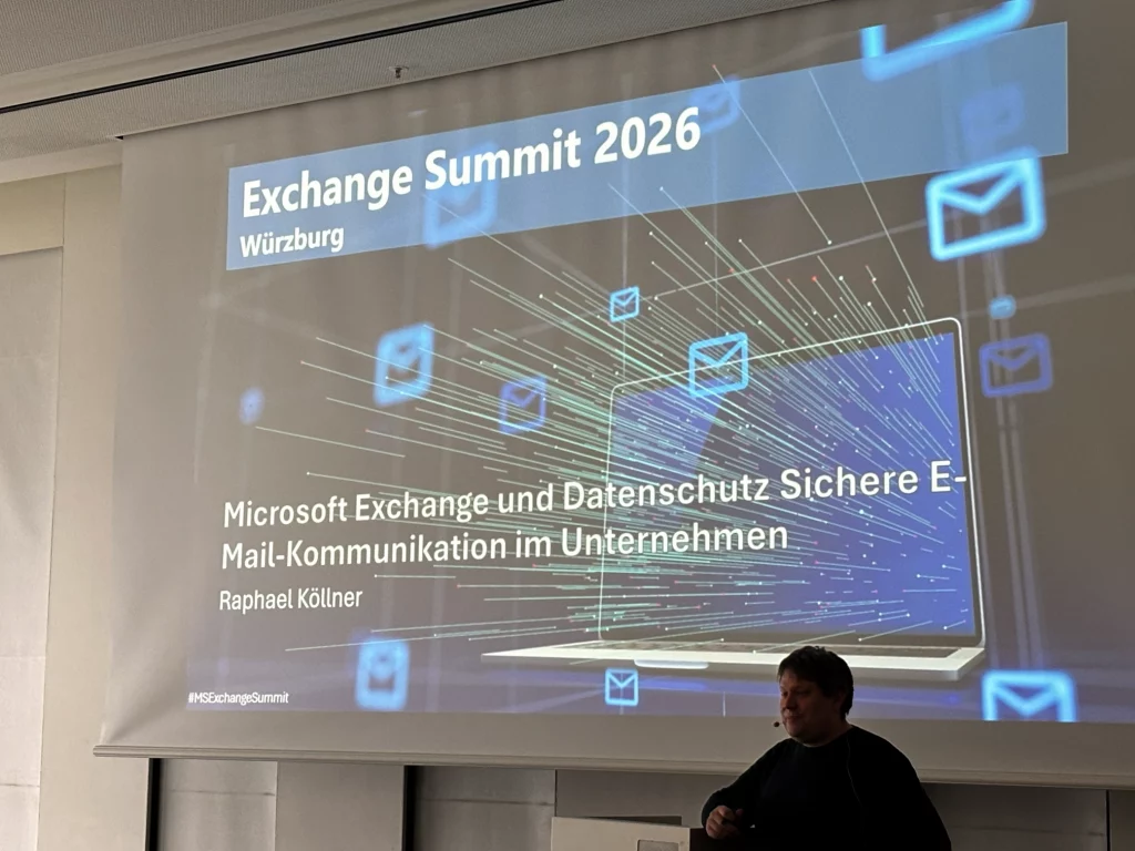 Präsentationsaufnahme in einem Konferenzraum: Auf der großen Leinwand ist eine Folie über „Exchange Server 5.0“ zu sehen, inklusive einer Übersicht der neuen Funktionen, eines historischen Screenshots des Exchange Web Clients sowie eines Zeitungsausschnitts zur damaligen Veröffentlichung. Im Vordergrund sitzt ein Publikum, während Scott Schnoll rechts am Rednerpult steht. Foto: Thomas Stensitzki